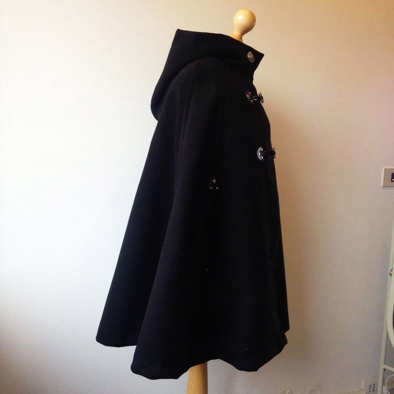 May include: Black hooded cape with a long, flowing design and silver button closures.