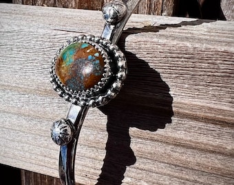 Turquoise stone on a Sterling Silver Bracelett with silver flowers