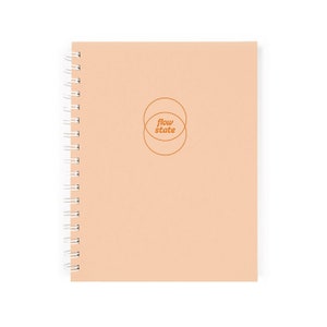 May include: A peach-coloured spiral bound notebook with the text "flow state" in orange inside two overlapping circles.