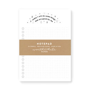 May include: A white notepad with a brown label that says "NOTEPAD 50 SHEETS RECYCLED PAPER MADE IN USA worthwhile PAPER". The notepad has a dotted grid pattern and a quote at the top that says "today I will do some things that are good for me".