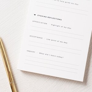 May include: A white journal with a black pen lying on top. The journal has a section titled "Evening Reflections" with prompts for appreciation, acceptance, and inquiry.