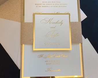 May include: Gold and white wedding invitation with a gold glitter envelope. The invitation features the names Kimberly and Tyler, the date 08.09.2019, and the text "St. Joseph Catholic Church" and "416 N. Downing, Joliet, Illinois".