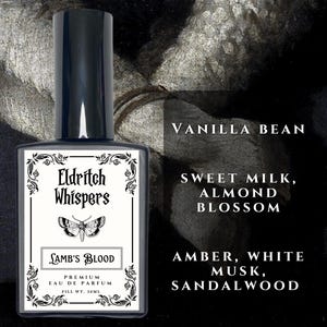 May include: A rectangular glass perfume bottle with a black cap and a white label featuring the text Eldritch Whispers, Lamb's Blood, Premium Eau de Parfum, and Fill Wt. 30ml. The label includes a moth illustration and lists scent notes: Vanilla Bean, Sweet Milk, Almond Blossom, Amber, White Musk, and Sandalwood.