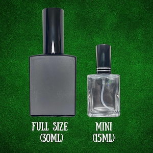 K&ouml;nnte beinhalten: Eine mattschwarze rechteckige Spr&uuml;hflasche mit der Aufschrift FULL SIZE (30ML) und eine durchsichtige rechteckige Glasspr&uuml;hflasche mit der Aufschrift MINI (15ML). Beide Flaschen haben schwarze zylindrische Kappen auf gr&uuml;nem Grund.
