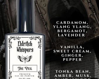 May include: A rectangular glass perfume bottle with a dark cap and a white label featuring the text Eldritch Whispers, The Veil, and Premium Eau de Parfum, with a moth illustration. The label lists ingredients: Cardamom, Ylang Ylang, Bergamot, Lavender, Vanilla, Sweet Cream, Ginger, Pepper, Tonka Bean, Amber, Musk, Sandalwood. Fill weight 30ml.