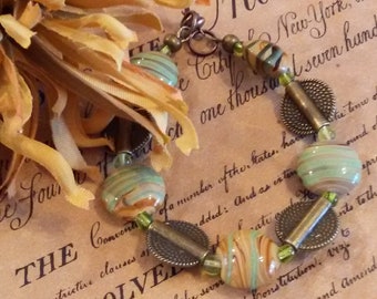 Lampworked glass beaded bracelet, Sage green and caramel striped lampworked beads with antique bronze paddle spacers