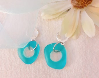 Aquamarine beach glass earrings, circles of glass hang from silver plated lever back ear wires