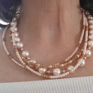Peach and champagne necklace. 4 strands of pearls and seed beads with a gold plated magnetic clasp