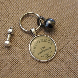 It's "PROGRESS NOT PERFECTION" Workout Keychain. Choice of barbell or kettlebell weight lifting charm