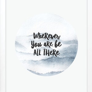 May include: A white framed print with a watercolor background in shades of blue and gray. The print features the quote "Wherever you are, be all there." by J. Ellio. The print is on a white surface with the words "raincity prints" in black.