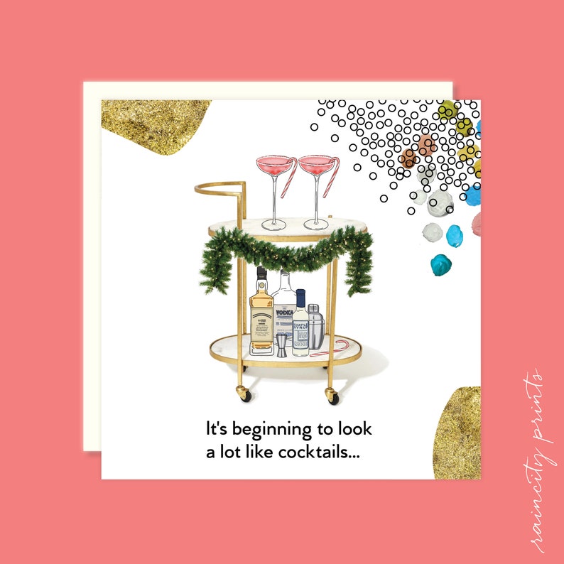 May include: A gold bar cart with a garland of greenery and bottles of liquor. Two pink cocktails are on the top shelf. The text "It's beginning to look a lot like cocktails..." is below the cart.