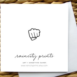 Puede incluir: Una tarjeta de felicitaci&oacute;n blanca con una ilustraci&oacute;n de pu&ntilde;o negro y el texto "raincity prints" en fuente cursiva negra. Debajo del texto se encuentra "ART + GREETING CARDS" y la direcci&oacute;n del sitio web "www.raincityprints.etsy.com".