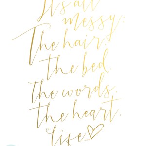 May include: Gold calligraphy on a white background with the text "It's all messy: The hair. The bed. The words. The heart. Life..."