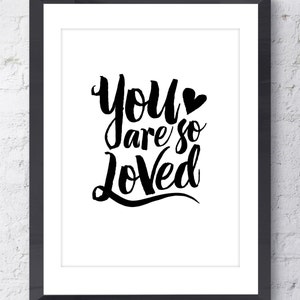 May include: Black and white typography print with the text "You are so Loved" in a stylized font with a small heart symbol.