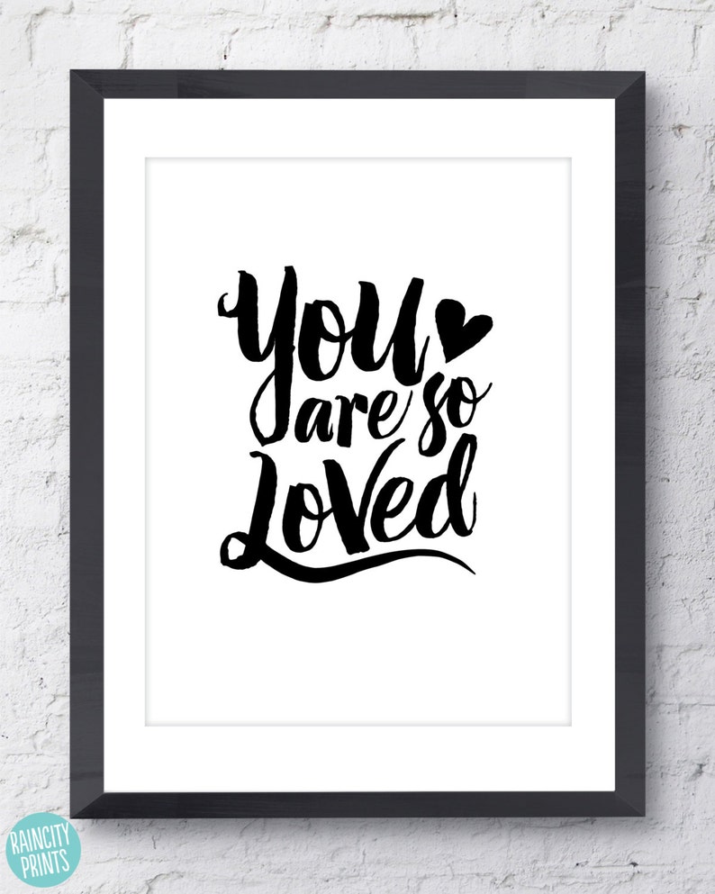 May include: Black and white typography print with the text "You are so Loved" in a stylized font with a small heart symbol.