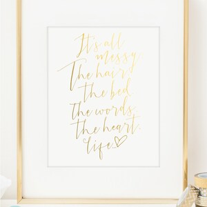 May include: Gold foil print with the text "It's all messy: The hair, the bed, the words, the heart, life..." with a heart symbol at the end.