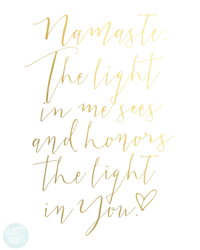 May include: A white print with gold calligraphy. The text reads "Namaste. The light in me sees and honors the light in You!" A small heart symbol follows the word "You". The words "RAINCITY PRINTS" are in the lower left corner.