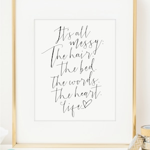 May include: Black and white printable wall art with a handwritten quote that reads "It's all messy: The hair, the bed, the words, the heart, life..." with a small heart symbol at the end.