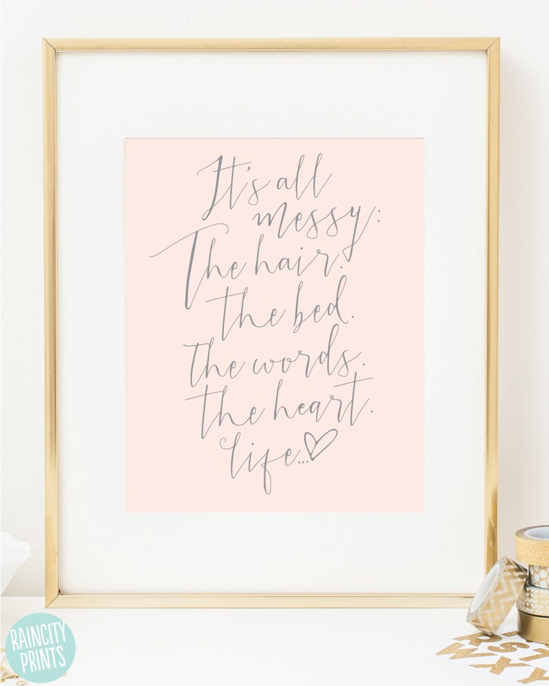 May include: A pink background with a gray cursive quote that reads "It's all messy: The hair. The bed. The words. The heart. Life..." with a small heart symbol at the end.