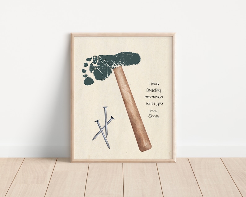 May include: A framed print with a green footprint shaped like a hammer and three silver nails. The print has the text "I love building memories with you, love, Shelly".