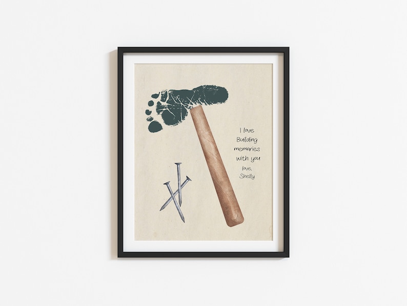 May include: A framed print with a green footprint shaped like a hammer and three silver nails. The print has the text "I love building memories with you, love, Shelly".