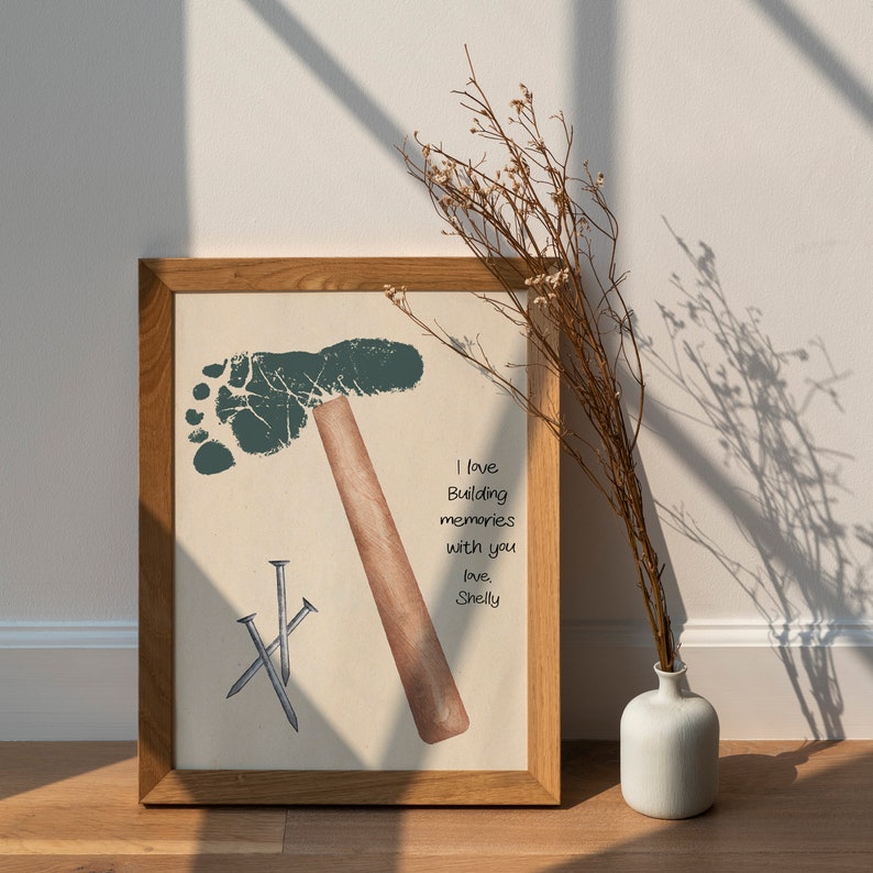 May include: A framed print with a green footprint shaped like a hammer, three silver nails, and the text "I love building memories with you, love, Shelly".