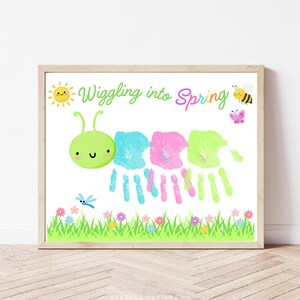 Puede incluir: Un estampado enmarcado con un diseño de oruga colorido. El cuerpo de la oruga está hecho de huellas de manos en azul, rosa y verde. El estampado incluye el texto "Wiggling into Spring", un sol, una abeja, una mariposa y flores.