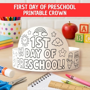 May include: A white paper crown featuring black line art for coloring, with the text 1ST DAY OF PRESCHOOL! surrounded by illustrations of a rainbow, sun, cloud, butterfly, star, pencil, and crayon, designed for children to color and wear.