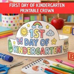 May include: A white paper crown featuring the text 1ST DAY OF KINDERGARTEN! in colorful letters. The design includes illustrations of a rainbow, a smiling sun, a cloud, a butterfly, a backpack, and a box of crayons, all outlined in black ink.