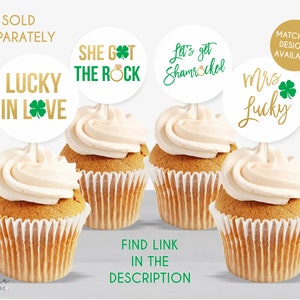 May include: Four round cupcake toppers on white sticks featuring green and gold text and shamrock graphics. The text reads LUCKY IN LOVE, SHE GOT THE ROCK, Let's get Shamrocked, and Mrs Lucky. Each topper is displayed above a frosted cupcake.