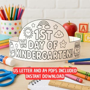 May include: A white paper crown for coloring with the text 1ST DAY OF KINDERGARTEN! featuring line art illustrations of a sun, rainbow, clouds, butterfly, star, backpack, and crayon box. The crown is surrounded by colored pencils, a glue stick, and a ruler.