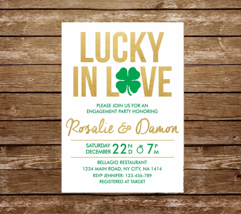 May include: A white rectangular engagement party invitation card featuring the gold text LUCKY IN LOVE with a green four-leaf clover replacing the letter O. The card includes the names Rosalie and Damon in gold script and green text details.