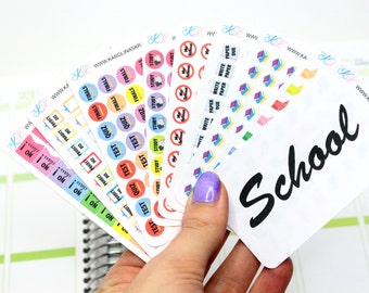 May include: A set of colorful school-themed stickers with various designs, including circles with the words "Test", "Quiz", "Finals", and "Study", as well as rectangular stickers with the words "I'm on it" and "The Project is Due". The stickers are arranged in a fan shape and held by a hand. The bottom sticker has the word "School" written in black cursive.