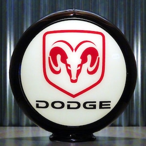 May include: A black and white gas globe with a red Dodge logo featuring a ram's head. The logo is surrounded by a black ring.
