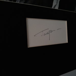 Puede incluir: Una tarjeta blanca con una firma en tinta negra que dice "Tamayo".