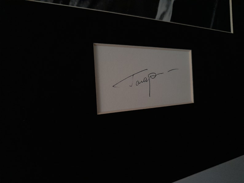 Puede incluir: Una tarjeta blanca con una firma en tinta negra que dice "Tamayo".