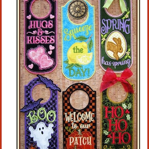 Può includere: Sei appendiporta colorati con diversi design e motti. I design includono cuori, limoni, un coniglio, un fantasma, una zucca e agrifoglio. I motti includono "Hugs & Kisses", "Squeeze the Day", "Spring has sprung", "Boo", "Welcome to our Patch" e "Ho Ho Ho".