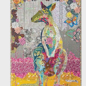 Peut inclure: Une courtepointe colorée représentant un kangourou orné de motifs floraux. Le kangourou est entouré d'une bordure florale sur un fond gris. On y trouve un papillon et le texte "Kangaroo by Laura Heine".