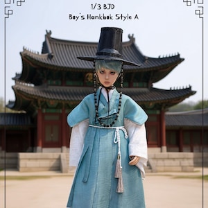 Puede incluir: Muñeca vestida con un traje tradicional coreano Hanbok. El conjunto incluye una chaqueta y falda verde azulado, un sombrero negro y un collar de cuentas. Se puede ver el texto "1/3 BJD Boy's Hanbok Style A".