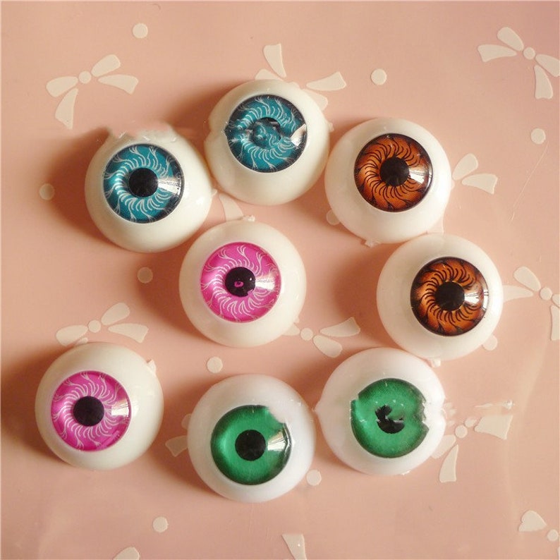 May include: Assortment of eight colourful doll eyes with different iris patterns. The eyes are made of plastic and have a white base.