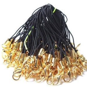 May include: A bulk pack of black string with gold lobster claw clasps. The string is approximately 18 inches long and is ideal for making keychains, phone charms, or other small crafts.