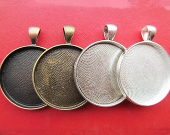 May include: Four round metal pendant trays with a textured surface. The trays are silver, bronze, and black.