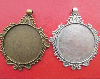 May include: Two ornate metal picture frames with a circular opening. The frame on the left is bronze and the frame on the right is silver.