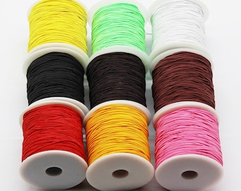 May include: Eight spools of colorful elastic cord, each wound on a white plastic spool. The colors are yellow, green, white, black, brown, red, yellow, and pink.