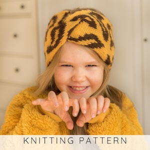 May include: A child wearing a mustard yellow knitted headband with a brown animal print. The child is also wearing a mustard yellow fuzzy jacket. The text "KNITTING PATTERN" is at the bottom of the image.