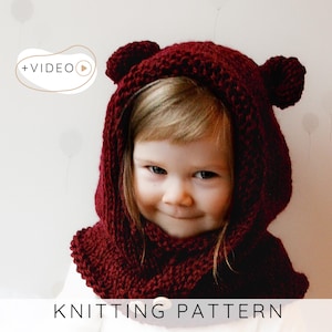 May include: A child wearing a knitted burgundy bear hood with ear details. The hood is part of a knitting pattern, as indicated by the text at the bottom of the image. The image also includes a "+VIDEO" icon.