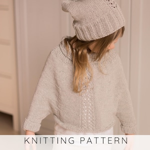 Peut inclure: Un pull en tricot gris clair et un bonnet assorti. Le pull présente un motif texturé central unique. Le texte "KNITTING PATTERN" est affiché en bas de l'image.