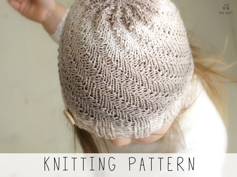 toddler in light hand knitted hat with a spiral texture, knitting pattern to make kids hat