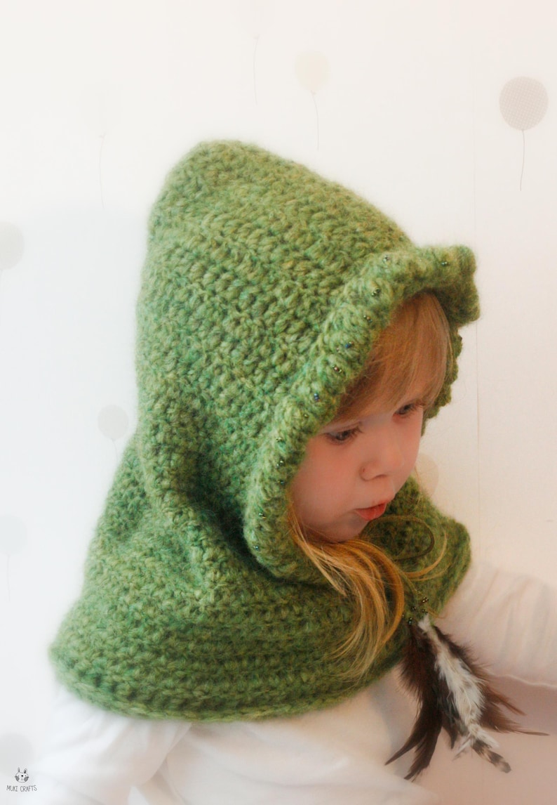 Peut inclure: Un capuchon vert crochet&eacute; avec un bord &agrave; volants et un accent de plumes. Le capuchon est d'une nuance de vert vif et semble &ecirc;tre fait &agrave; la main. Le capuchon est con&ccedil;u pour &ecirc;tre port&eacute;, probablement comme un costume ou un accessoire.