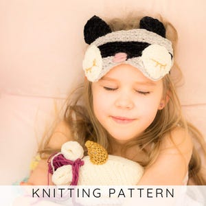 May include: A child wearing a handmade sleep mask with a raccoon design, featuring black, gray, and white colors. The mask has large, round ears and eye shapes. The text "KNITTING PATTERN" is at the bottom of the image.